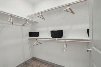 a walk in closet with shelves and hangers on the wall at The Maddox Luxury Apartment Homes, Buckeye, AZ